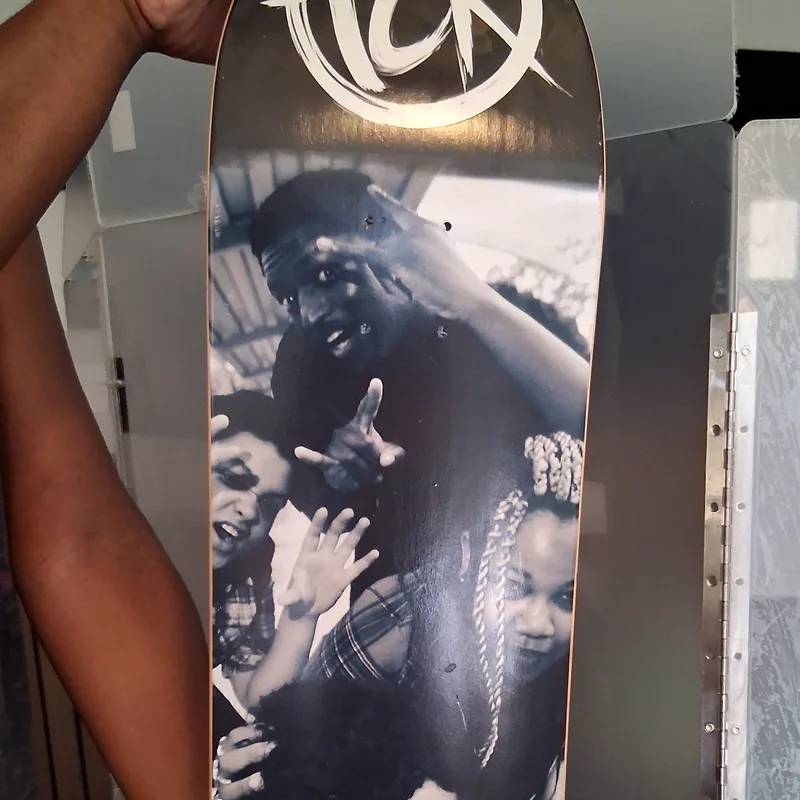 Skateboard deck printed with a black-and-white band photo and TCR logos
